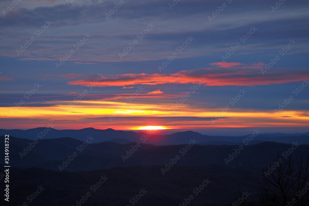 Colorful sunrise over layered mountains after ice storm in Blowing Rock, North Carolina.