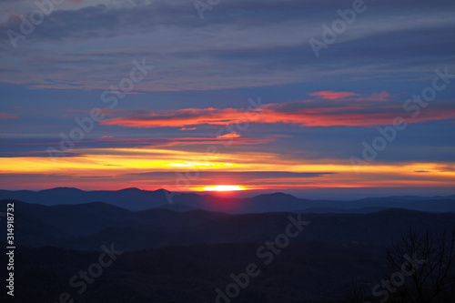 Colorful sunrise over layered mountains after ice storm in Blowing Rock, North Carolina.