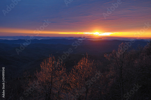 Fototapeta Naklejka Na Ścianę i Meble -  Colorful sunrise over layered mountains after ice storm in Blowing Rock, North Carolina.