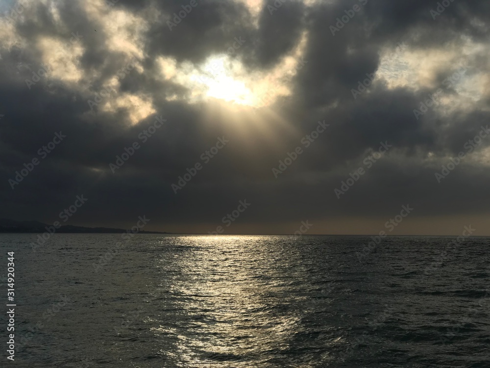 sunrise over the mediterranean sea, sunshine from behind the clouds over the sea andalusia spain esuropa,