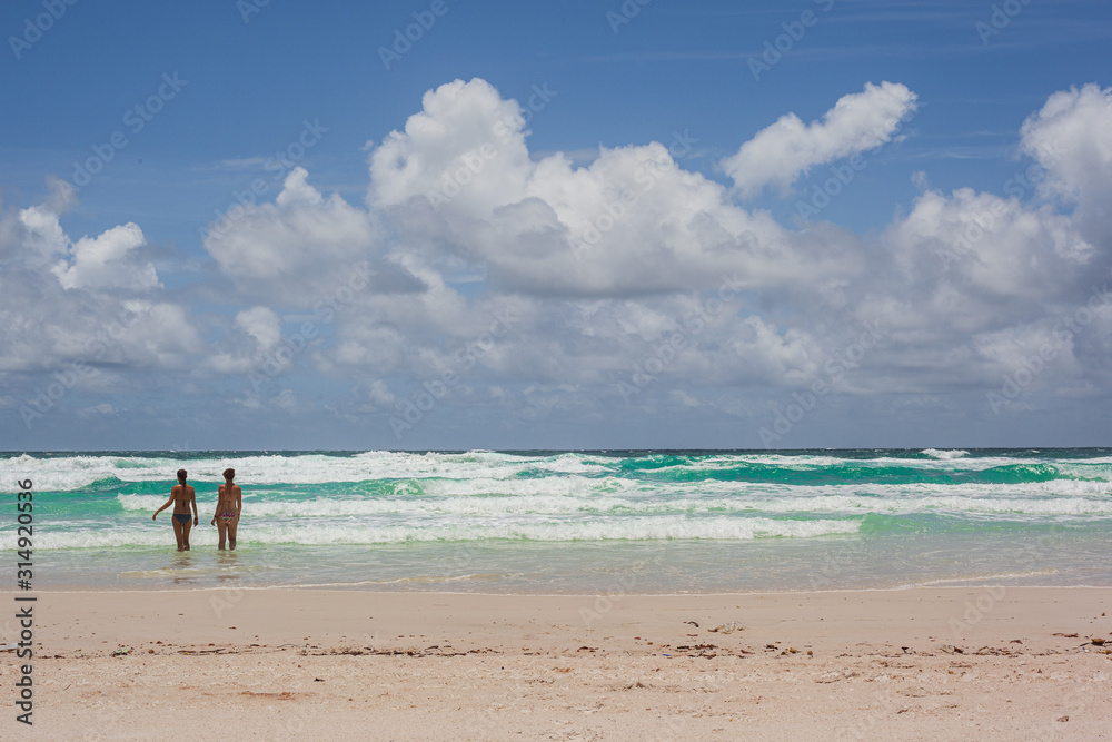 Chicas en el agua de playa de arena blanca