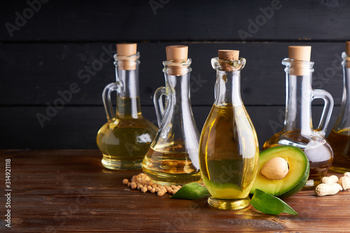 Healthy vegetable oils in glass bottles. Avocado oil  chickpea oil  linseed oil  peanut oil  almond oil. Dark background