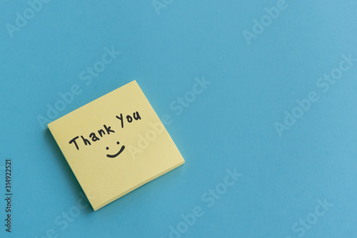 Thank you note on stocky note on blue background