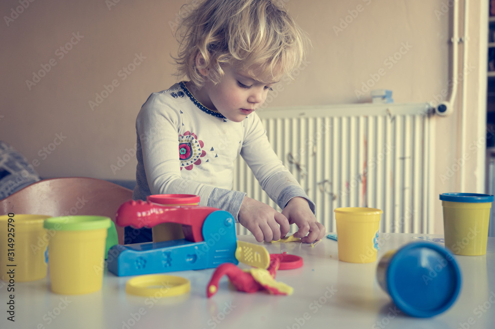 Cute girl playing with many colorful doughs. Cute girl playing with many colorful doughs.