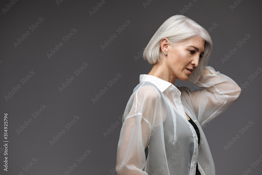 Business senior woman in white shirt on grey background Business senior woman in white shirt on grey background