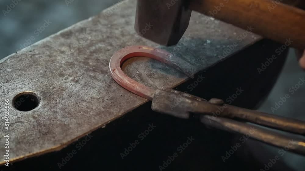 A hammer hitting a horseshoe in slow motion A hammer hitting a horseshoe in slow motion