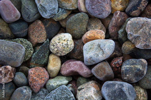 Multi-colored stones in the frost covered with hoarfrost