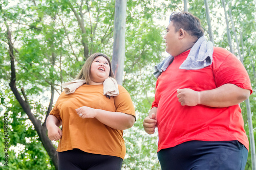 Portrait of fat Asian couple jogging happily
