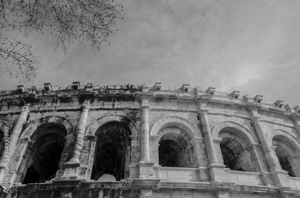 Nimes, France, 13 March, 2018: Roman Coliseum in Nimes South of France. Black & White the old version againts the new one.