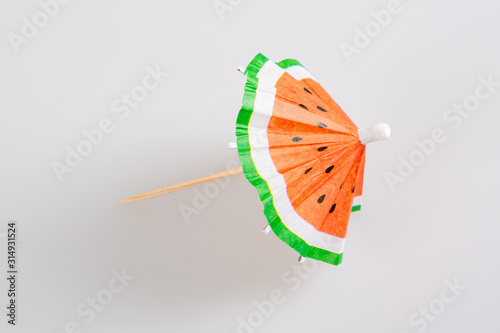 watermelon paper cocktail drink umbrella isolated on grey background photo