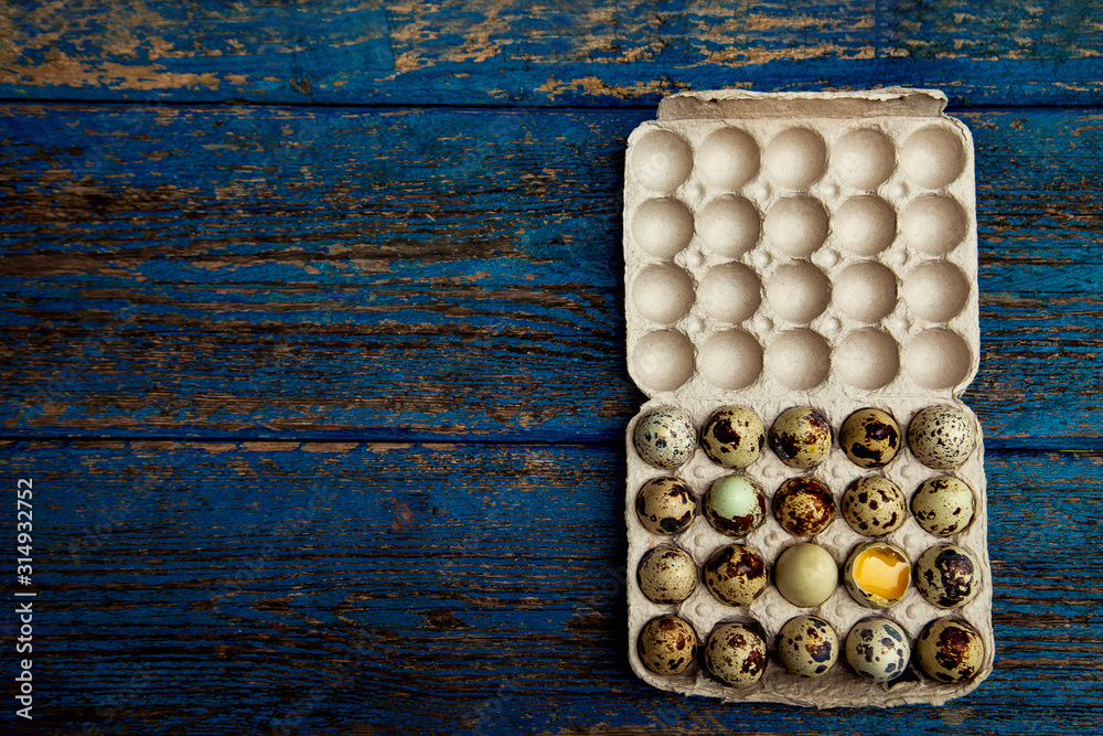a small quail egg, on a blue, wooden,old, shabby background a small quail egg, on a blue, wooden,old, shabby background