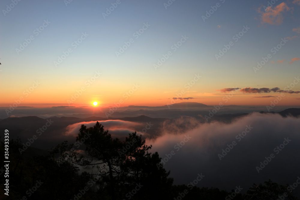 Beautiful scenery of mountain with mist sea, golden light shines on sky and sunrise up from the horizon at view point of Phu chi phoe in the early morning, Khun Yuam, Mae Hong Son, Thailand Beautiful scenery of mountain with mist sea, golden light shines on sky and sunrise up from the horizon at view point of Phu chi phoe in the early morning, Khun Yuam, Mae Hong Son, Thailand