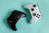 White and black two joystick gamepad, game console isolated on pastel blue colourful trendy background. Computer gaming competition videogame control confrontation concept. Cyberspace symbol.