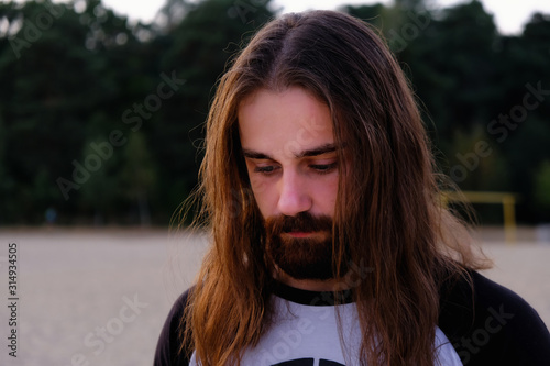 Portrait of handsome bearded young man with long hair photo