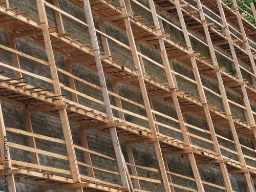 Wooden scaffolding reconstruction limestone wall