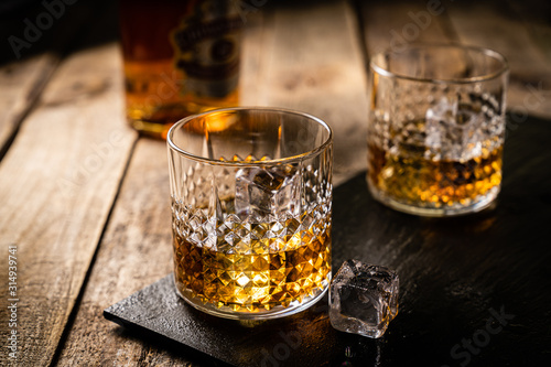Canvas Print Whiskey in glasses on wood background, copy space, toned