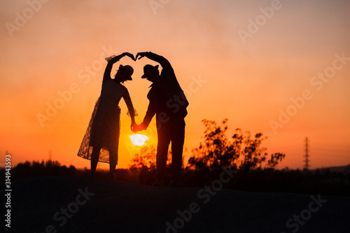 Bride and groom on top of hill. Couple newlyweds at wedding in nature forest, Wedding Couple with sunset and silhouette