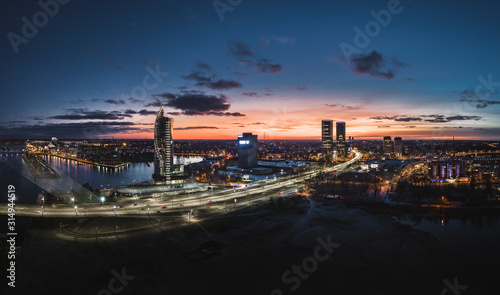 Obraz na płótnie Aerial view over Riga city at night time. Urban landscape with skyscrapers and highway with city lights. w salonie