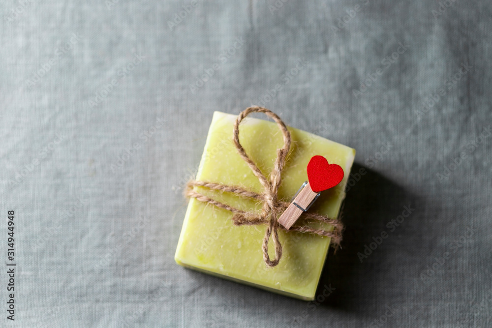 Natural handmade soap with a heart decor on a background of linen fabric. Natural handmade soap with a heart decor on a background of linen fabric.