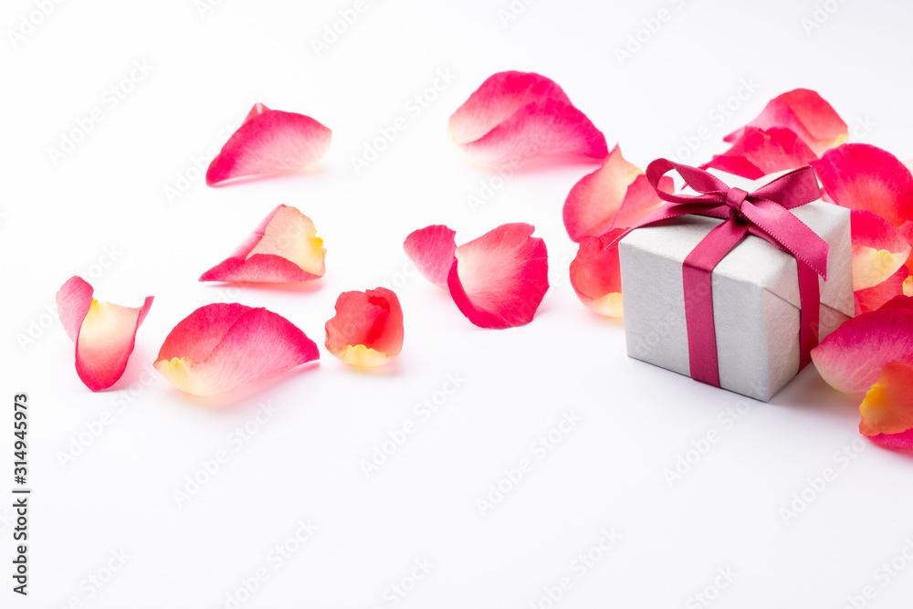 Petal and gift box on white background. Romantic concept for Valentine Day or Birthday. Space for text. 