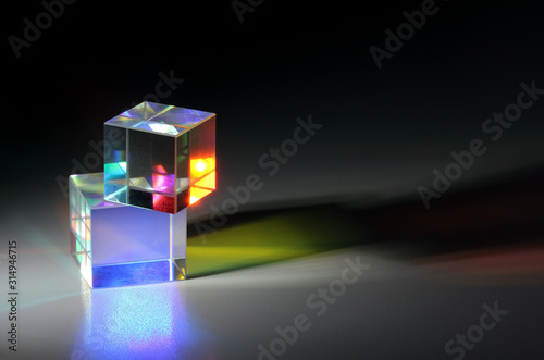Two bright luminous prism cubes refract light in different colors