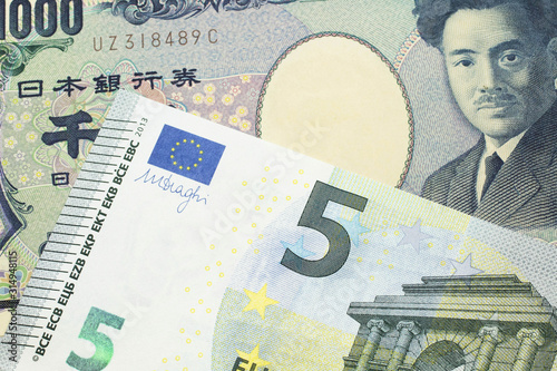 A one thousand Japanese yen bank note, close up in macro with a five Euro European bank note photo