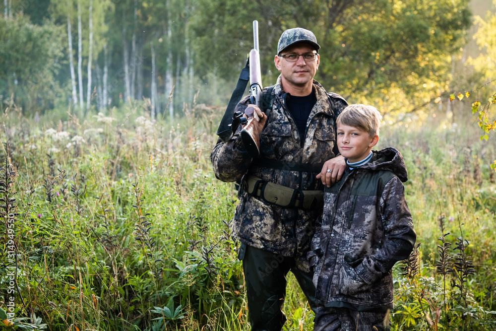 Father teaches his grandson to hunt in a woods