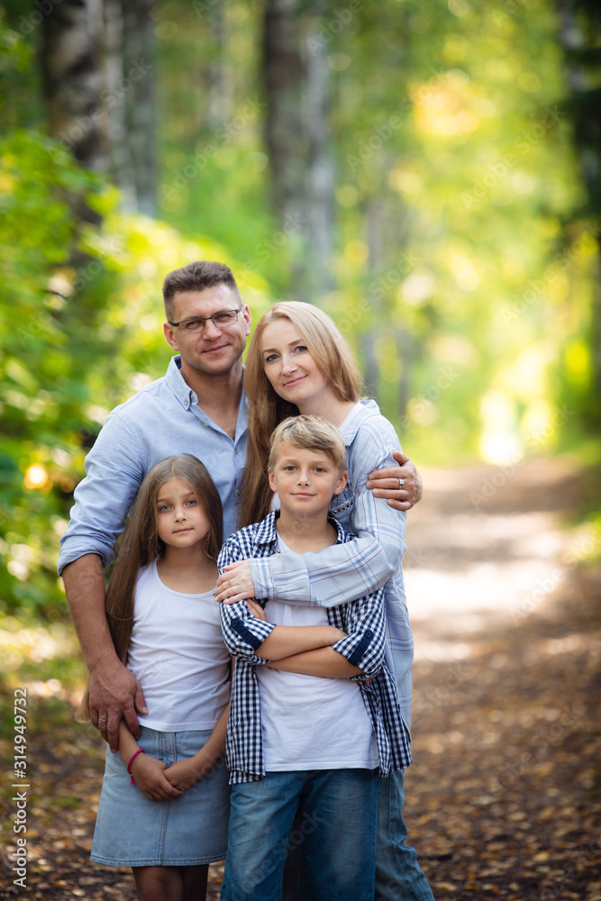 Happy family outdoors spending time together. Father, mother, daughter and son are having fun in a summer park at summer Happy family outdoors spending time together. Father, mother, daughter and son are having fun in a summer park at summer