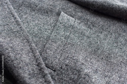 Close up of light grey woolen jacket with a pocket fragment.