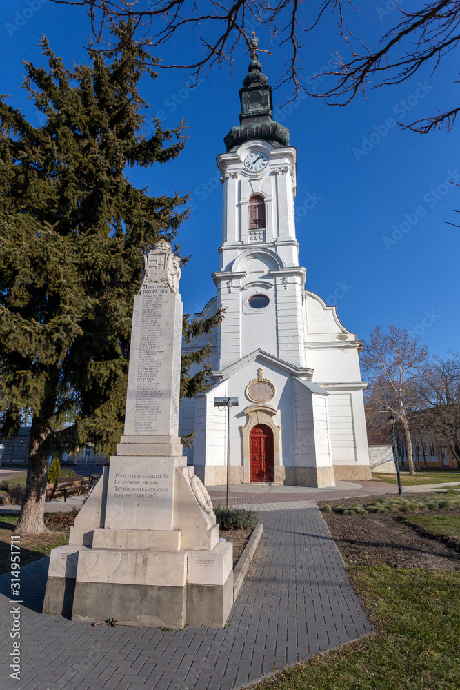 Baroque style calvinist  church with a World War I memorial in the foreground in Szabadszallas, Hungary