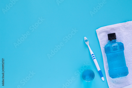 Flat lay composition with oral care products and copy space for text on blue background.