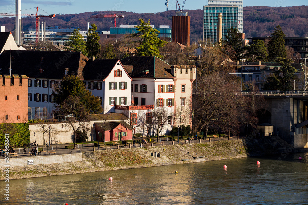 View on Basel city and river Rhine, Switzerland. Heritage, beautiful. Swiss city Basel in sunny weather in winter. View of the embankment and the river Rhine, in which people walk and relax