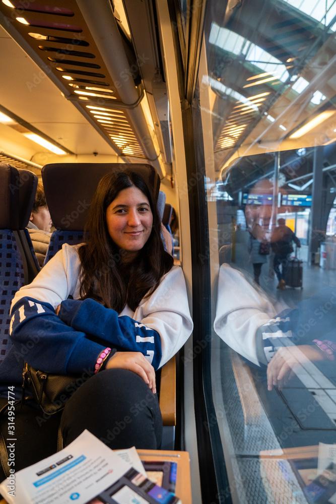Girl sitting inside a train next to the window