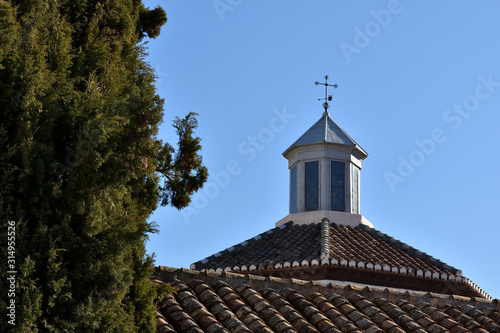 Nice dome with stained glass of San Bernardo in Granada view behind a roof with a large cypress beside it