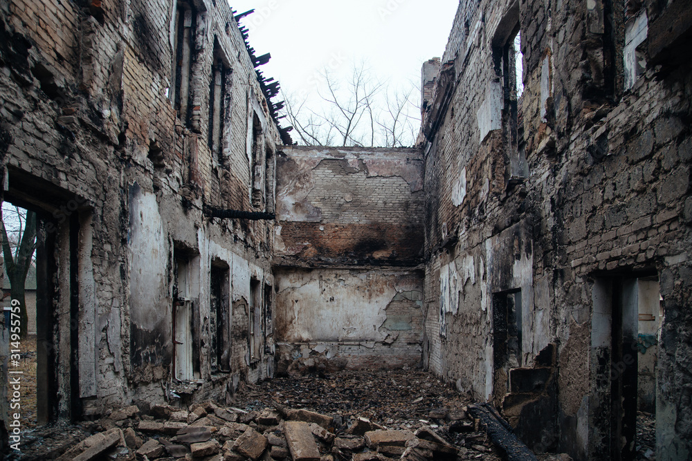 Fototapeta premium Completely burnt interiors and collapsed roof of the house after fire
