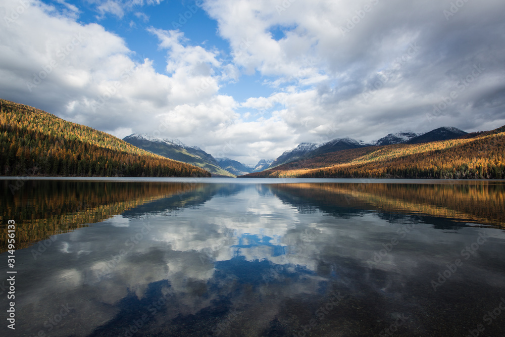 The reflection of sky and clouds on Bowman Lake in Glacier National Park. 