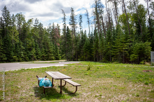 woman resting on picnic table bench in remote area