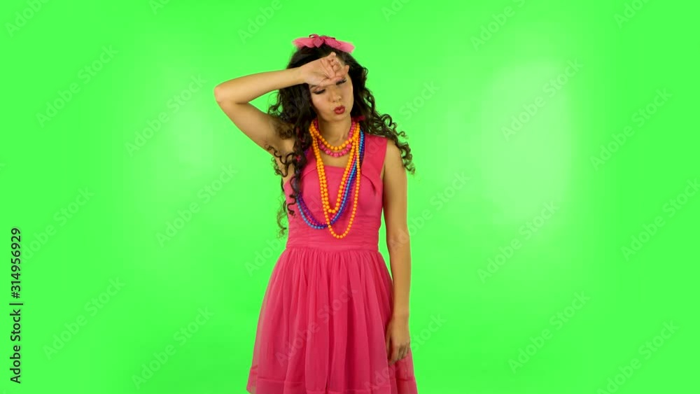 Woman is upset and tired on green screen at studio. Woman is upset and tired on green screen at studio.