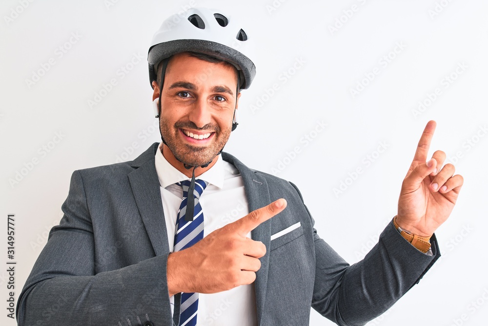Young handsome business man bike helmet and wireless earphones over isolated background smiling and looking at the camera pointing with two hands and fingers to the side. Young handsome business man bike helmet and wireless earphones over isolated background smiling and looking at the camera pointing with two hands and fingers to the side.