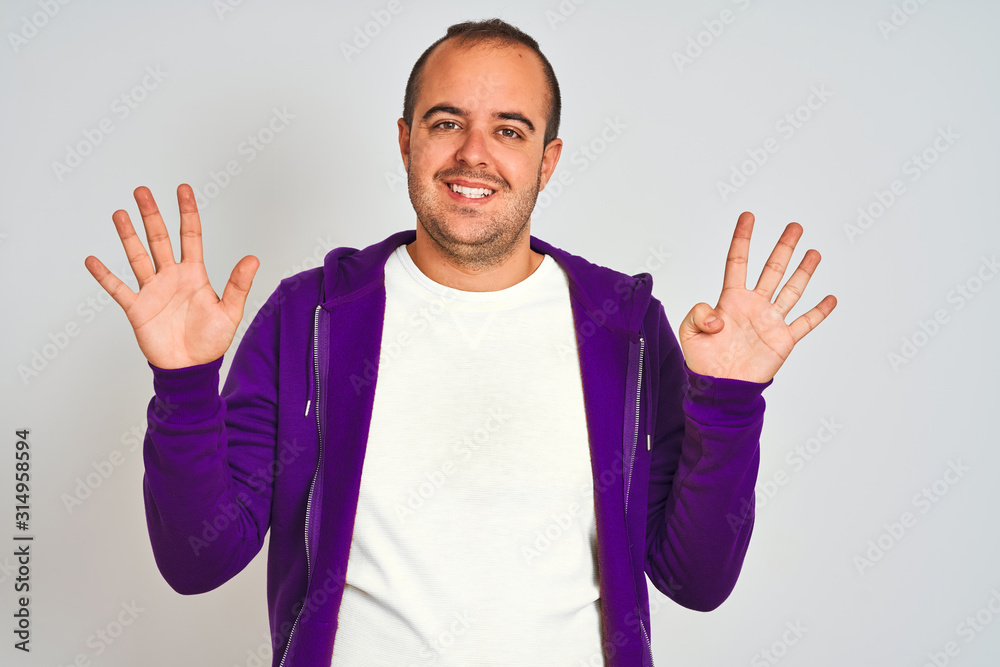Young man wearing purple sweatshirt standing over isolated white background showing and pointing up with fingers number nine while smiling confident and happy. Young man wearing purple sweatshirt standing over isolated white background showing and pointing up with fingers number nine while smiling confident and happy.