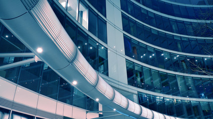 Night architecture - building with glass facade. Modern building in  business district. Concept of economics, financial. Photo of commercial office building exterior. Abstract image of office building