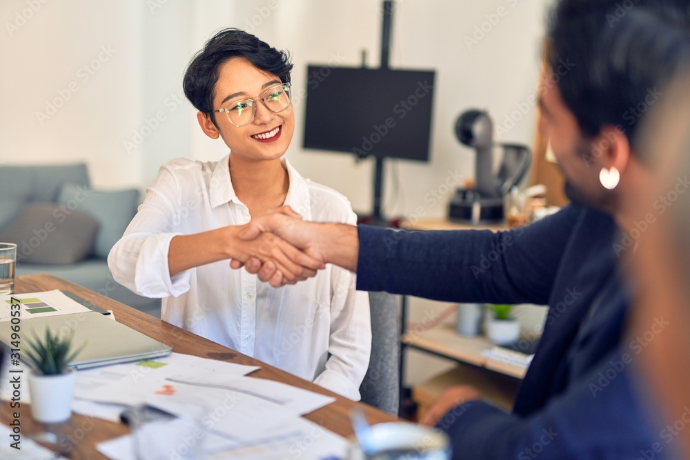 Group of business workers smiling happy and confident. Working together with smile on face shaking hands at the office