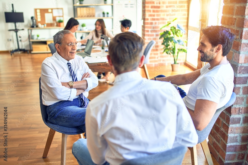 Handsome businessmen smiling happy. Sitting with smile on face speaking taking rest at the office Handsome businessmen smiling happy. Sitting with smile on face speaking taking rest at the office