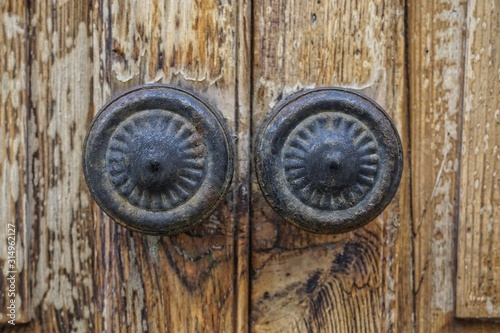 cast iron door knobs on old wooden door, in close up