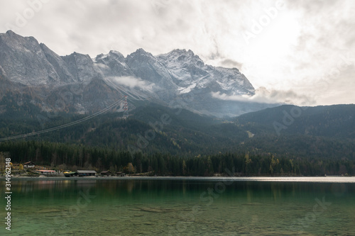 The sun behind the clouds, at Eibsee in front of Zugspitze