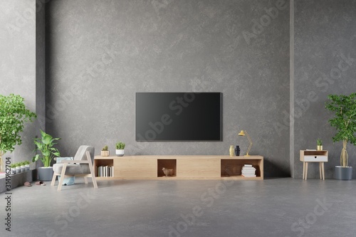 TV on cement stan in modern living room with lamp,table,flower and plant on cement wall background. photo