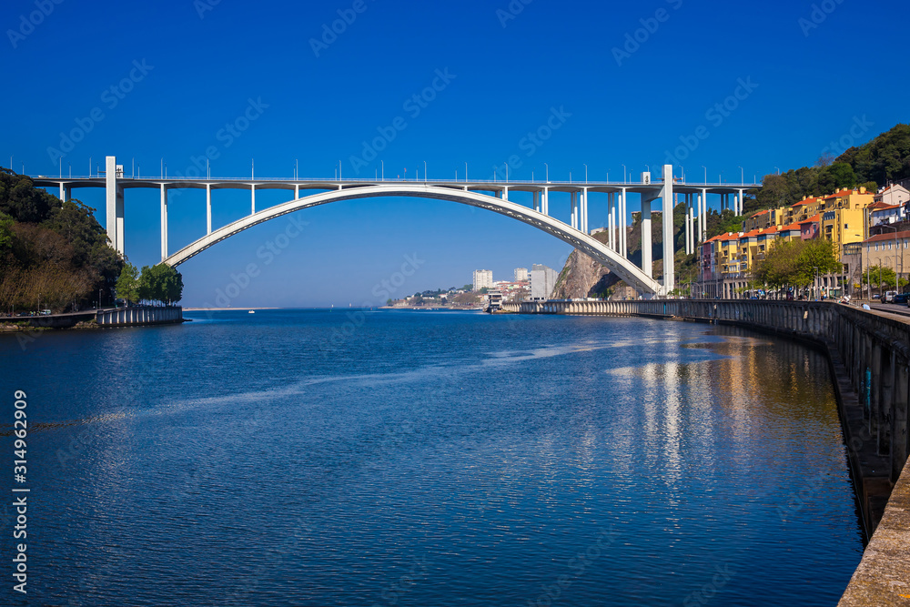 Naklejka premium View of the Douro River mouth and the Arrabida Bridge in a beautiful early spring day at Porto City in Portugal