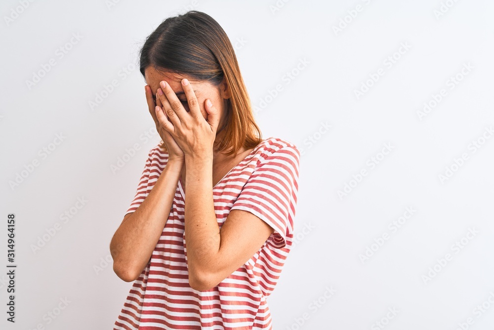 Beautiful redhead woman wearing casual striped red t-shirt over isolated background with sad expression covering face with hands while crying. Depression concept. Beautiful redhead woman wearing casual striped red t-shirt over isolated background with sad expression covering face with hands while crying. Depression concept.