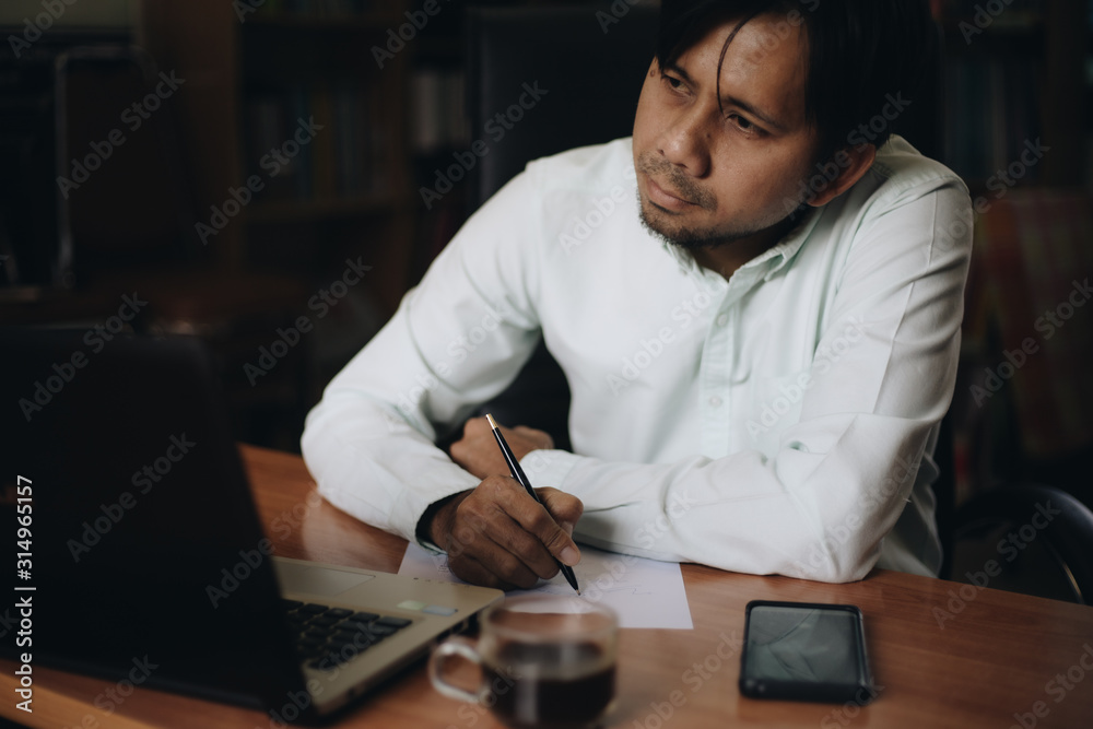 Asian businessman working with documents and laptop in his office
