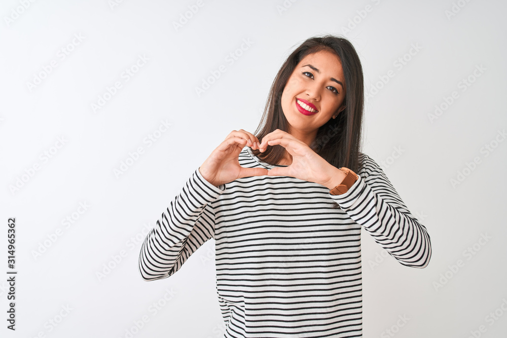 Young beautiful chinese woman wearing striped t-shirt standing over isolated white background smiling in love doing heart symbol shape with hands. Romantic concept. Young beautiful chinese woman wearing striped t-shirt standing over isolated white background smiling in love doing heart symbol shape with hands. Romantic concept.